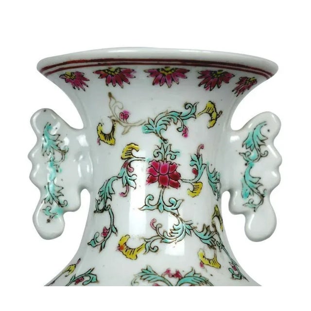This elegant Chinese porcelain vase features a predominantly white body, accented with green depictions of nature and lush...