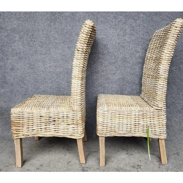 This splendid piece is comprised of a solid wood frame wrapped in natural rattan. The tall backrest curves backward for an...