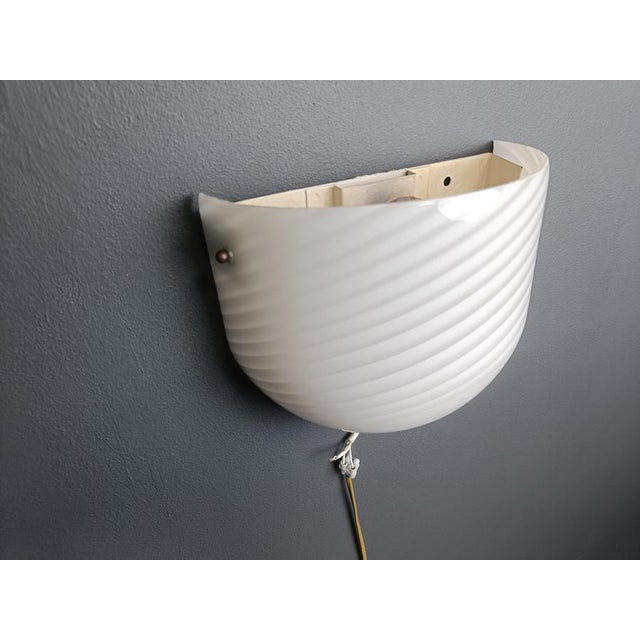 Vintage wall sconce in white swirl murano glass with structure in a white painted metal fixture with brass elements....