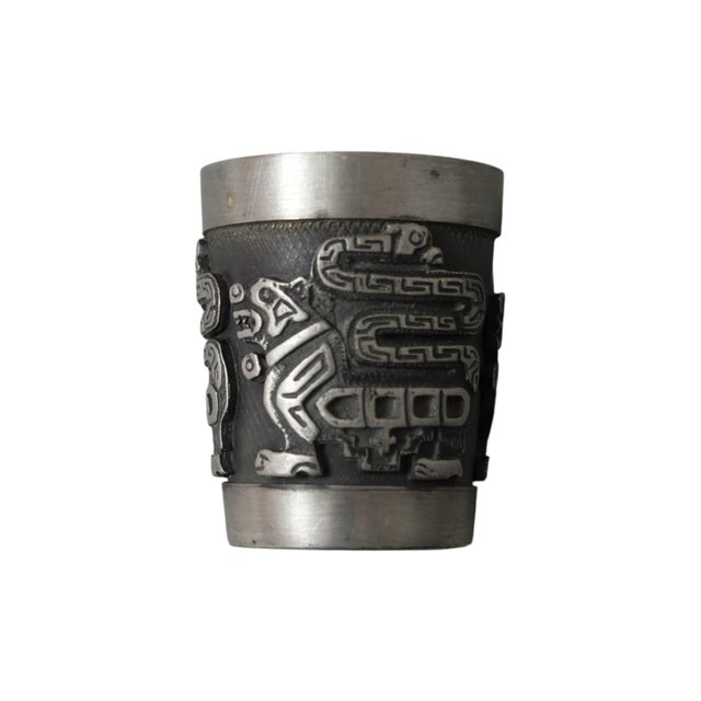 A set of six pewter shot glasses circa 1980, made by Creaciones Schohaus of La Paz, Bolivia. Each cup is decorated with...