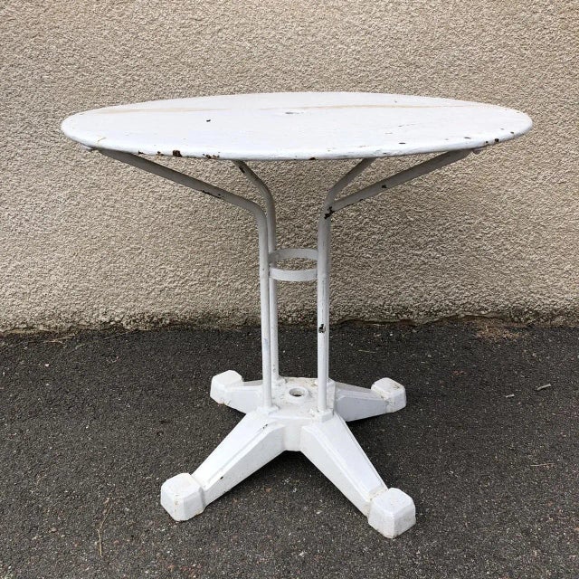 This garden table from the 1930s is composed of a cast iron base and four tubular columns terminated by hangers with...