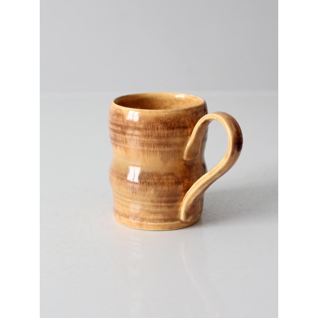 Vintage handmade studio pottery mug featuring warm honey and brown glazes with beautiful natural variation throughout....