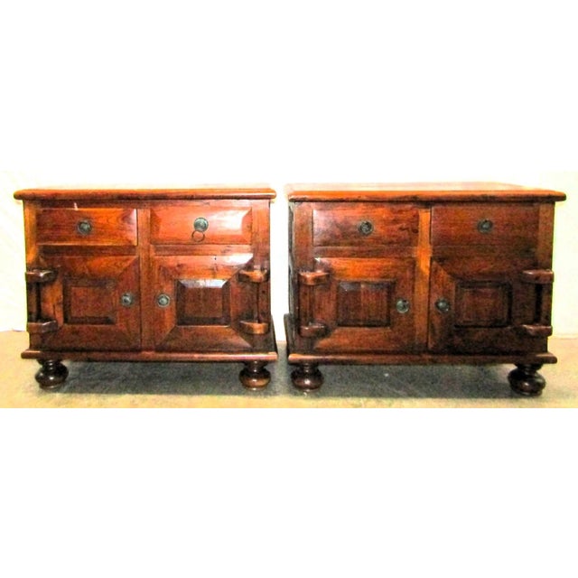 This is a pair of antique Dutch colonial nightstands/end tables from the 19th century, made of teak with a brown color....