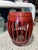 This wooden drum stool features an openwork barrel-shaped frame, decorative raised details, and a rich red painted finish....