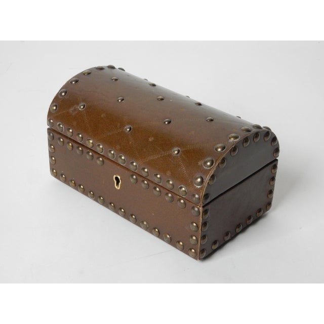 Wonderful leather clad jewelry box with bronze nailhead design and embossed "X" and stars. Red velvety lining. Has a lock...