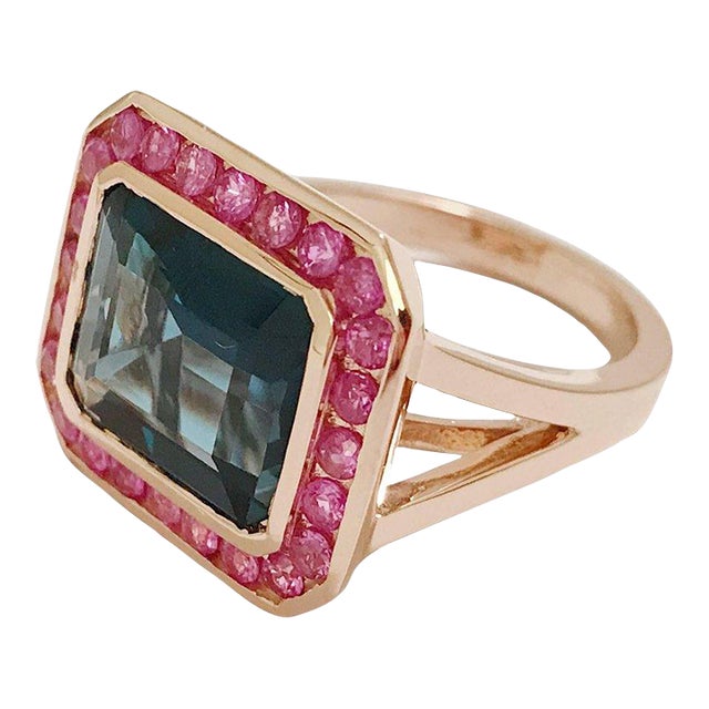 Rose Gold Bezel Set Dark Blue Topaz with Surrounding Pink Sapphire Ring For Sale