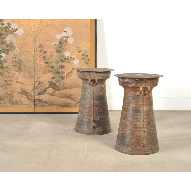 A handsome pair of 20th century patinated cast bronze Southeast Asian rain drums, frog drums, or side drink tables in a...