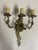 A set of eight gilt bronze Rococo style three-arm wall sconces with scrolling acanthus leaf arms curving outward to...