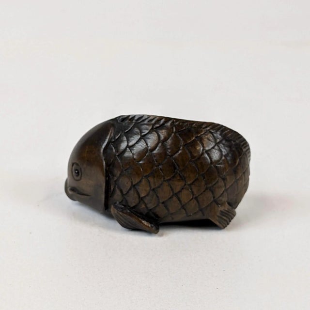 A delightful hand carved carp of hardwood. Artists signature is on the bottom. Traditional this is attached to a silk cord...