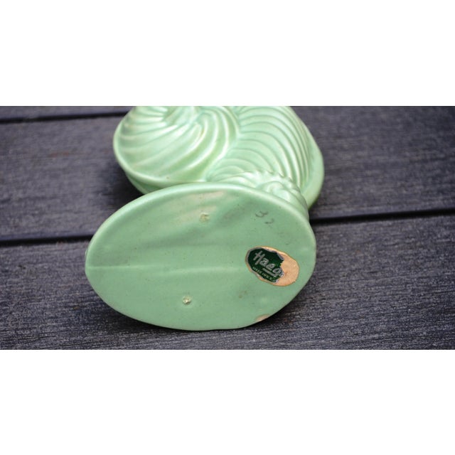 Nice matte mint green vase in the shape of a fiddlehead, a fern just starting to emerge from the ground. It is a unique...
