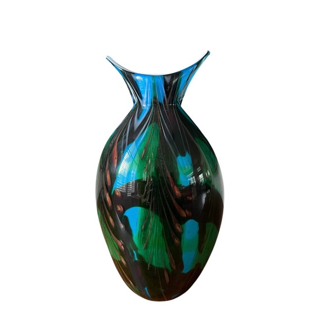 A striking sculptural art glass vase featuring a flared rim and rounded, organic body form. The richly layered coloration...