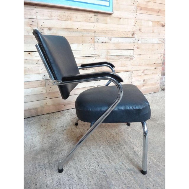 A stunning 1960s retro barber armchair, defined by its sleek chrome frame and classic mid-century styling. The chair...