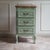 This narrow chest of drawers was likely made between 1950 and 1970 as a reproduction piece inspired by the french rococo...
