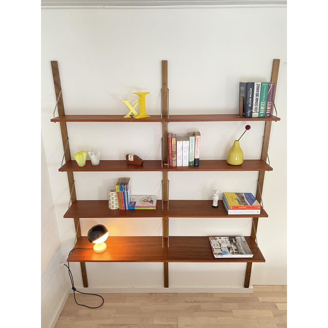 Elegant shelving system from the 1950s/60s in a mid-century design, stylistically reminiscent of the well-known Cado...