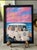 Charming framed art print featuring a white vintage van with five playful cats against a pastel pink and blue seaside sky....