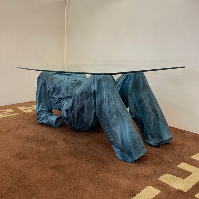 An astonishing coffee table in blue patinated resin sculpting lying down woman in full denim, supporting a large glass...