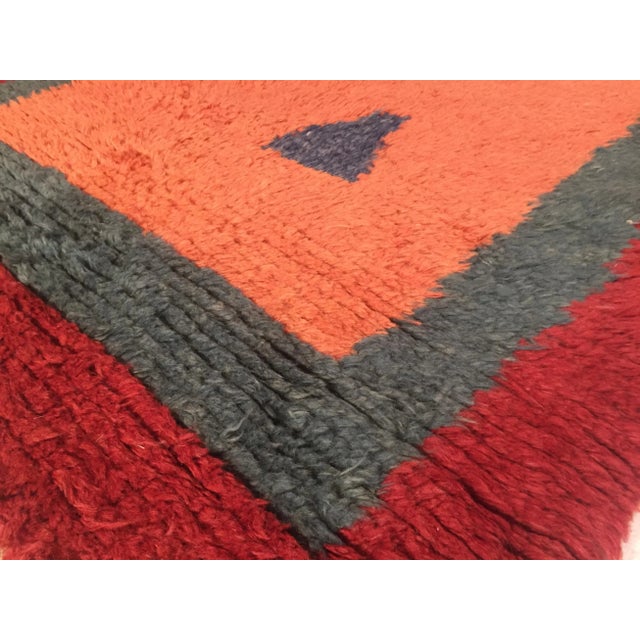 Tulu pink background decorated with polygons of various shapes and multicolored border. Despite the risky combination of...