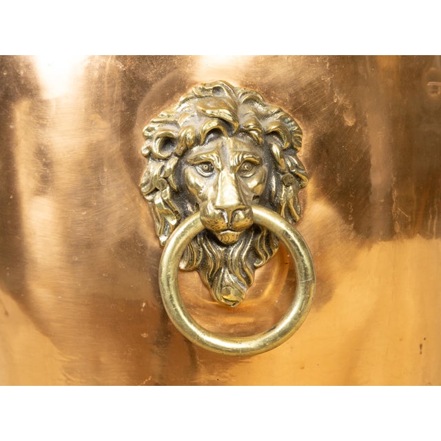 An English copper and brass cache pot planter from the early 20th century, with lion paw feet and lateral lion head...