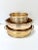 Three vintage oval brass cachepots in graduated sizes, with raised bands and rounded rims. The two larger planters have...