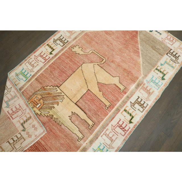 A vintage persian gabbeh rug with a lion motif