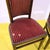Pair of wooden chairs featuring red upholstery and decorative studs.