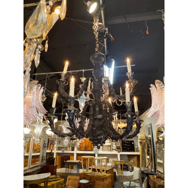 The 19th c. Italian Carved Wood and Iron Chandelier is a unique and elegant lighting fixture . The intricate detailing of...