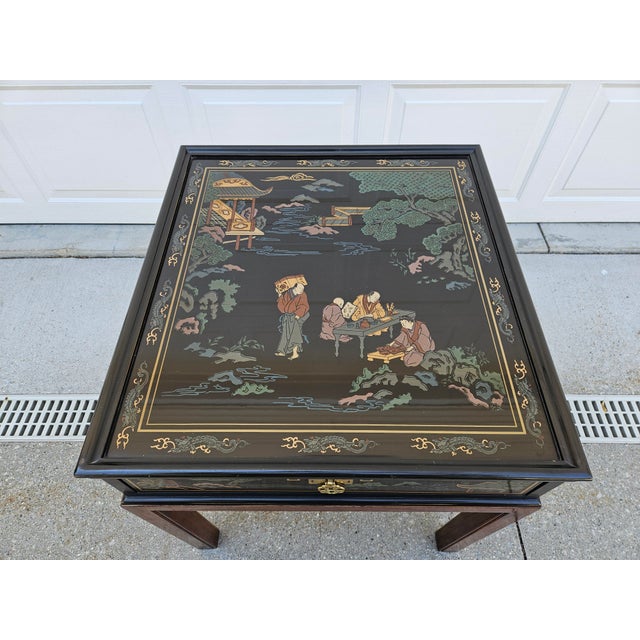 A Mid-Century Modern black lacquered Chinoiserie side table by Drexel. This piece features traditional landscape scenes on...