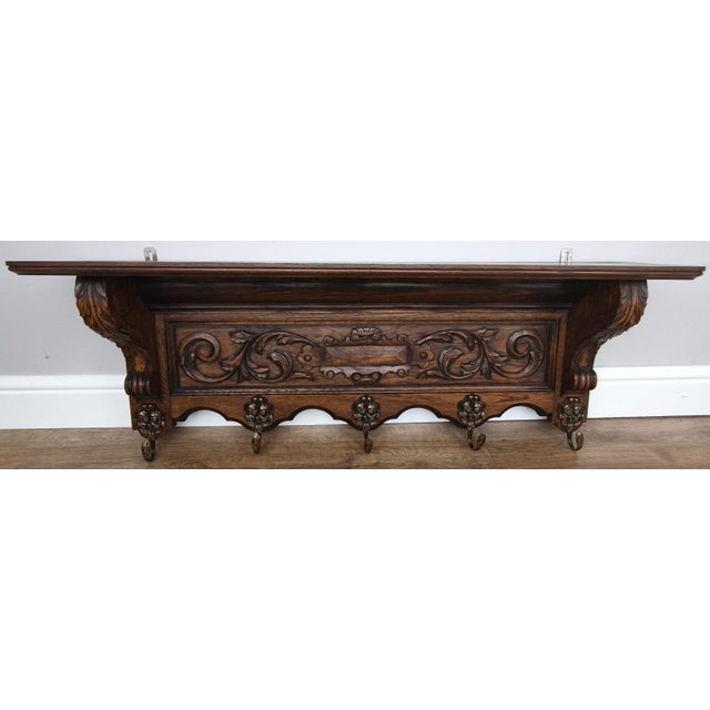 A beautifully crafted Vintage French coat hanger, showcasing rich oak tones and striking hand-carved detailing throughout....