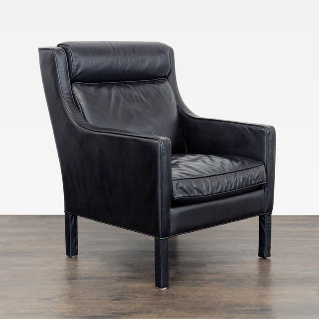 This Restoration Hardware lounge chair features a sleek black leather finish that adds a modern touch to any space. The...