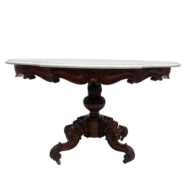 A 19th Century mahogany table with a cartouche-shaped marble top, ca 1840 A beautiful Dutch mahogany table with a four-...