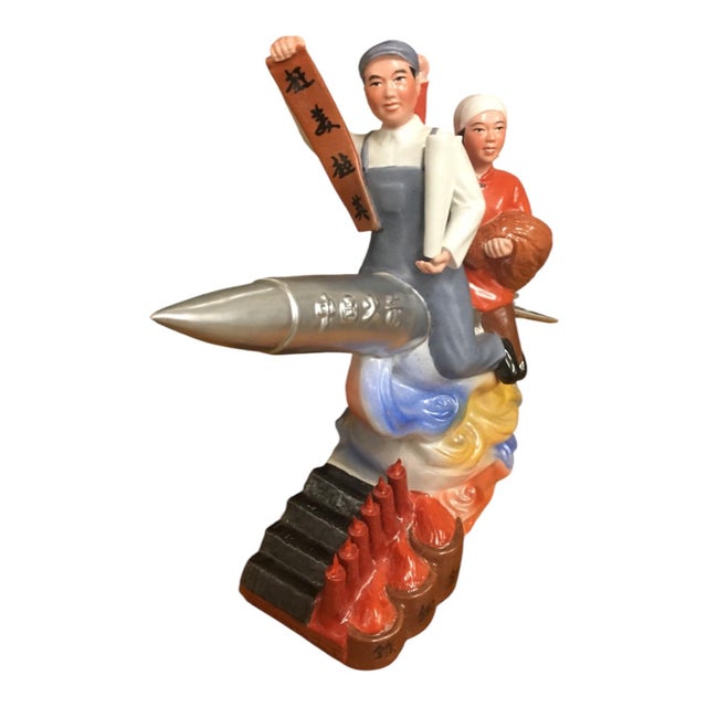 A rare unique original sculpture, peasants ride a blasting missile holding a scroll reading "We will Catch Up to you...