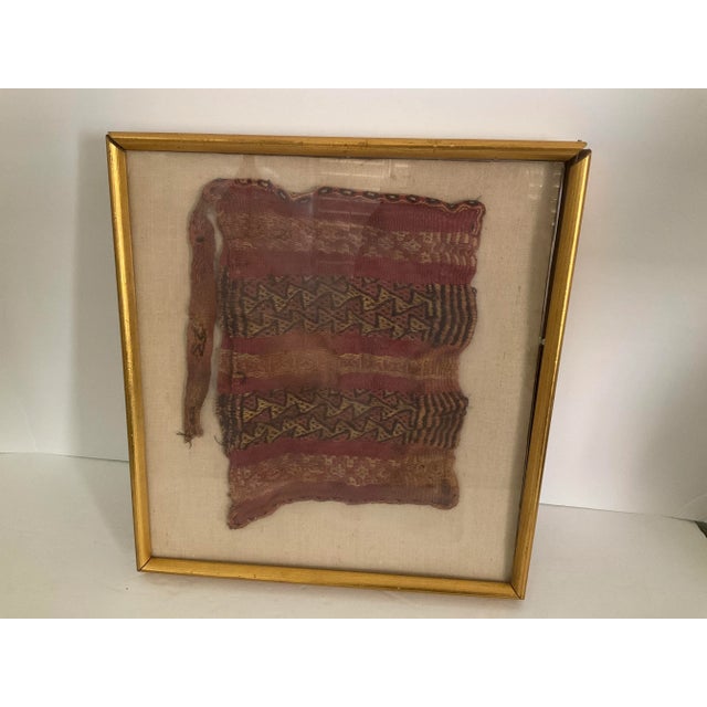 A Pre-Columbian Chimu textile satchel. A rare find! A geometric design mounted on linen and housed under a gilt frame. It...