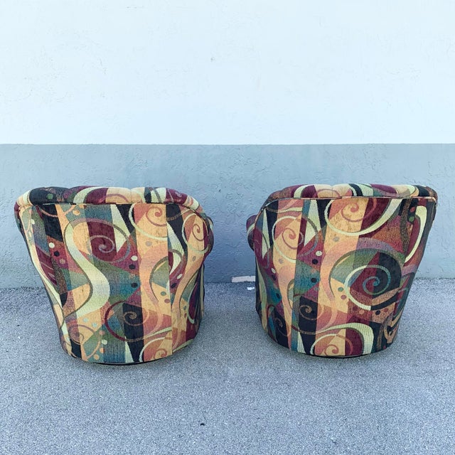 A bold expression of postmodern design, this pair of swivel club chairs features a vibrant abstract upholstery with...