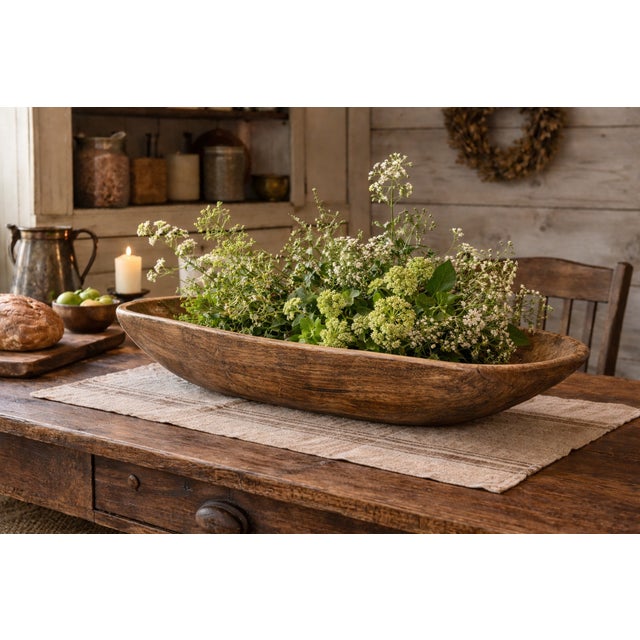 A substantial mid-19th century American farmhouse dough bowl hand-hewn from a single block of oak and measuring an...