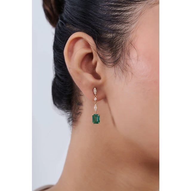 Elevate your jewelry collection with these elegant natural emerald and diamond dangle earrings, beautifully crafted in...