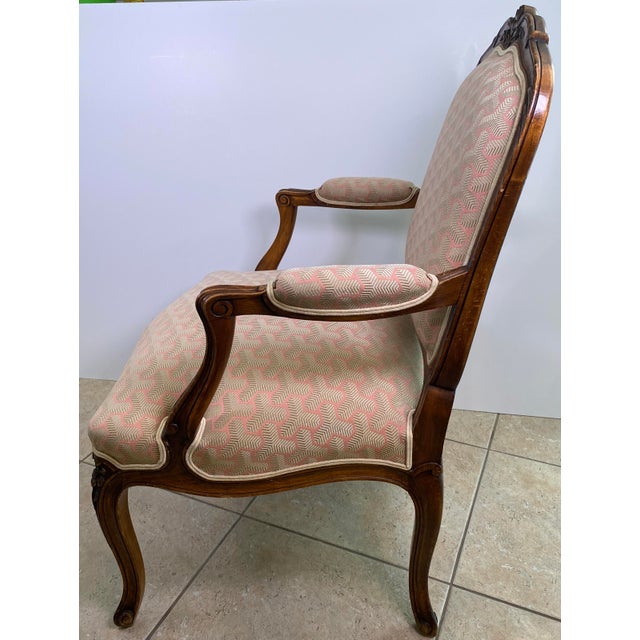 A refined pair of French Louis XV style bergère armchairs, crafted in richly toned walnut and distinguished by elegant...