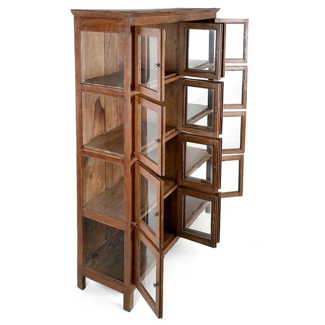 This solid wood glazed cabinet, equipped with 8 compartments each opening via 2 glass doors (i.e. 16 doors in total),...