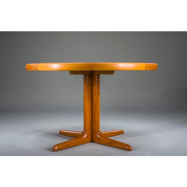 Elegant round mid-century dining table crafted in teak with a beautifully figured veneer. Professionally refreshed in our...