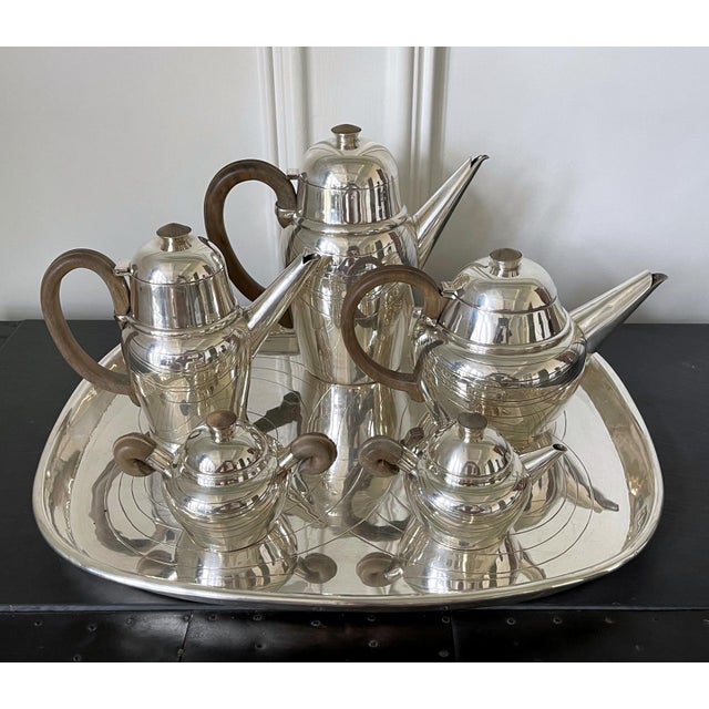 A large six-piece sterling silver service for coffee and tea that consists of a gallery tray, a coffee pot, a tea pot, a...