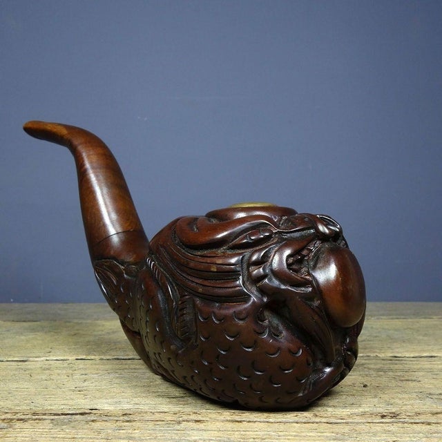 This is a finely carved antique rosewood tobacco pipe, featuring a bold, deep-relief dragon motif. The bowl is shaped into...