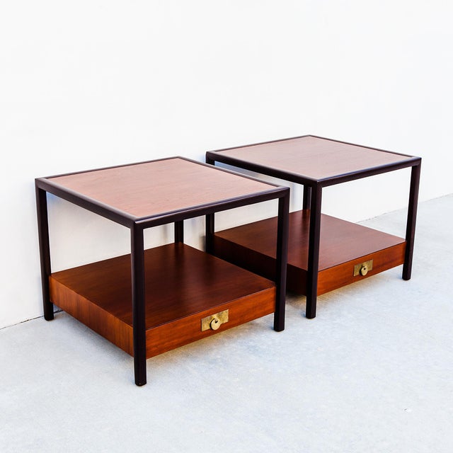 A pair of newly refinished teak and mahogany two-tier end tables by Michael Taylor for Baker’s “New World” collection,...