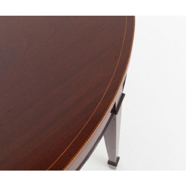 Mahogany Sheraton style demi lune table Circa 1880 This table is raised upon tapered legs with spade feet The legs, frieze...