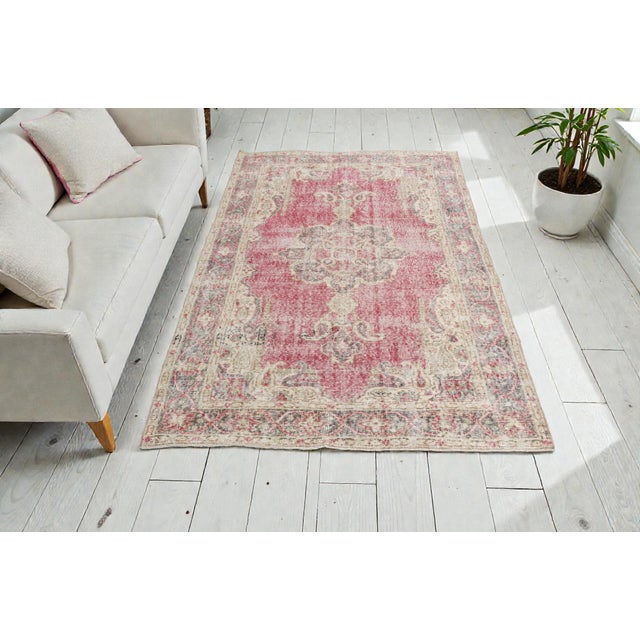 This is a vintage Turkish Oushak rug from the Mid 20th Century. The piece was hand-knotted.