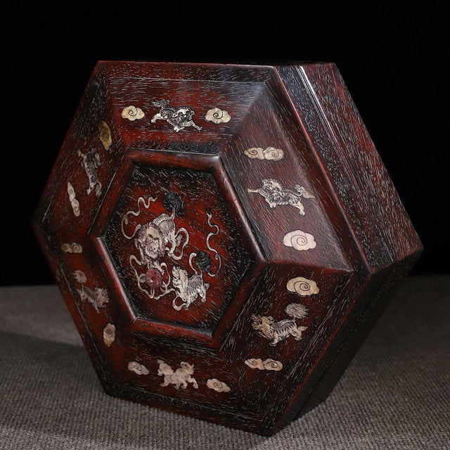 A beautifully crafted Chinese hexagonal box, likely made of Zitan wood. The piece features a faceted, domed lid that opens...