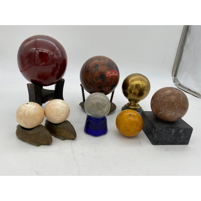 Collection of 8 Spheres featuring 4 in marble and stone, 2 resin, 1 Ceramic and one in brass. Seven come with bases. The...