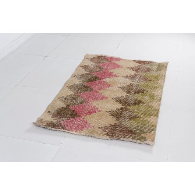This is a vintage Turkish Oushak rug from the Mid 20th Century. The piece was hand-knotted.