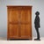 Walnut wardrobe. Front with two-part paneled doors, matching the sides, forty-five-degree uprights, and turned feet....