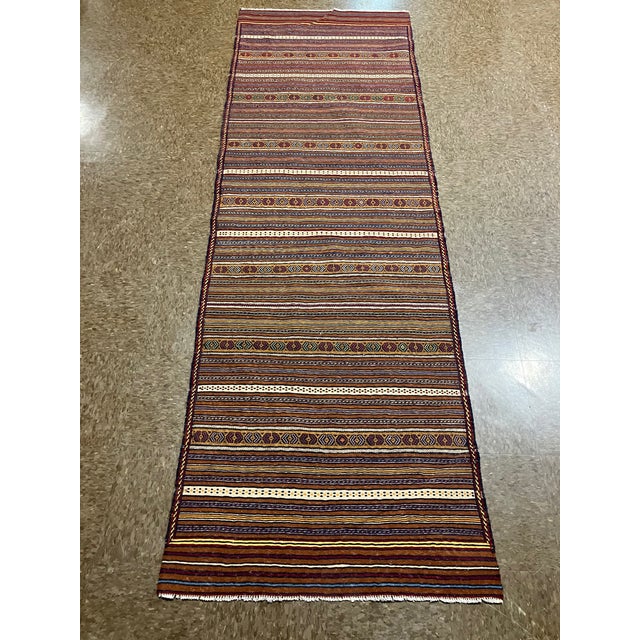 Handwoven Afghan Meymana kilim flatweave runner featuring a striped field with alternating horizontal bands of fine...