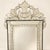 A Venetian style wall mirror made almost entirely of glass. The beveled center plate is framed by etched mirror panels of...