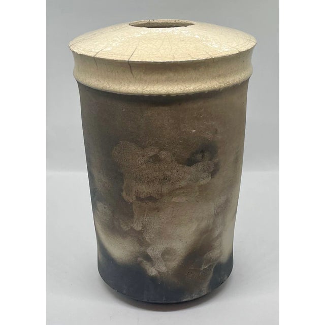 Unique Modern Vase in neutral palette of cream and black. The cream part of the vase has a crackle glaze. While the body...
